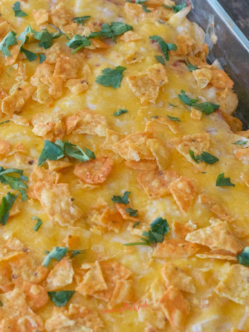 Dorito Chicken Casserole in a black bowl next to a pan of Dorito Chicken Casserole